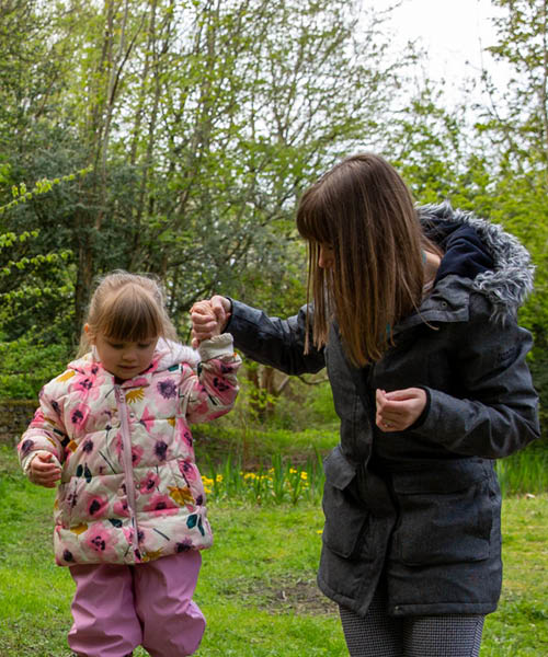 Parent and child walking through the woods.