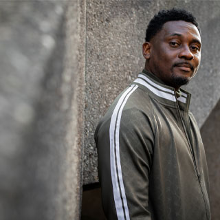 A student standing near a wall looking at the camera