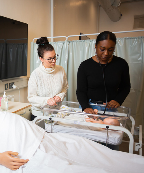 Midwifery students caring for a manikin baby