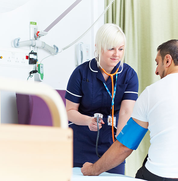 A student nurse testing the blood pressure of a patient.