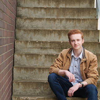 Connor, a marketing student, smiling at the camera.