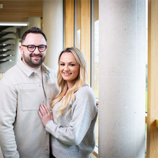 Two students standing together and smiling at the camera